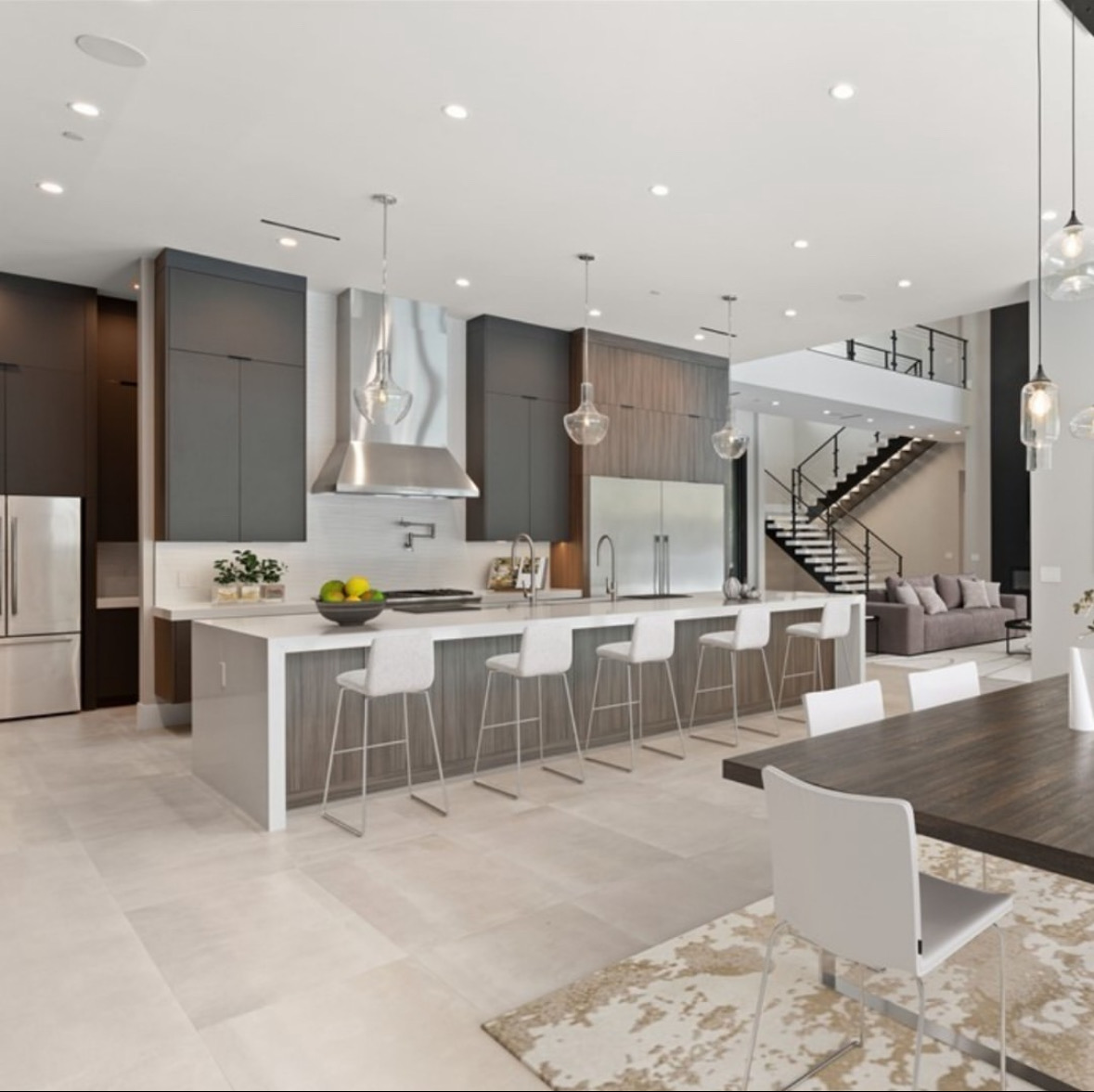Contemporary kitchen with a long waterfall island and pendant lighting
